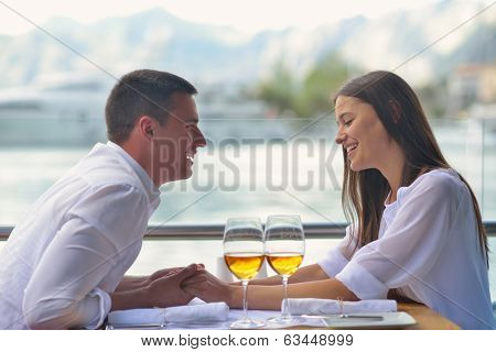 happy young couple having lanch at beautiful restaurant on by the sea on  beach