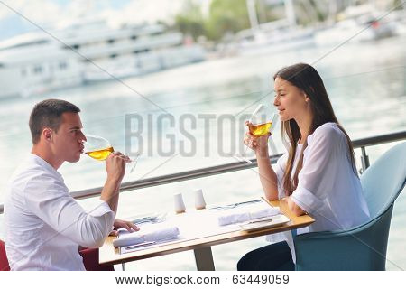 happy young couple having lanch at beautiful restaurant on by the sea on  beach