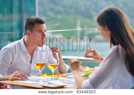 happy young couple having lanch at beautiful restaurant on by the sea on  beach