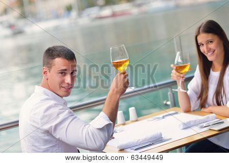 happy young couple having lanch at beautiful restaurant on by the sea on  beach