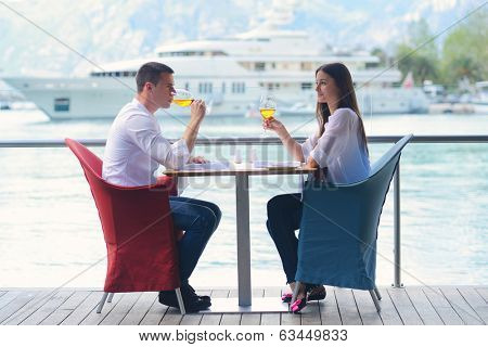 happy young couple having lanch at beautiful restaurant on by the sea on  beach
