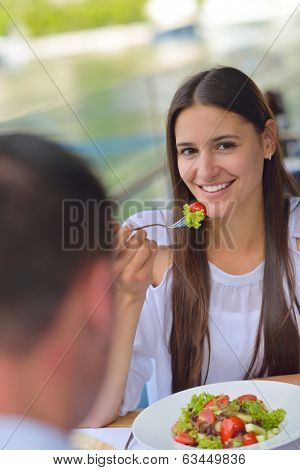 happy young couple having lanch at beautiful restaurant on by the sea on  beach
