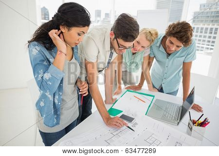 Group of fashion designers discussing designs in a studio