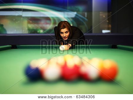 Young brunette girl playing snooker