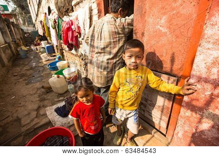 KATHMANDU, NEPAL - DEC 19, 2013: Unidentified local children near their homes in a poor area of the city. The caste system is still intact today but the rules are not as rigid as they were in the past