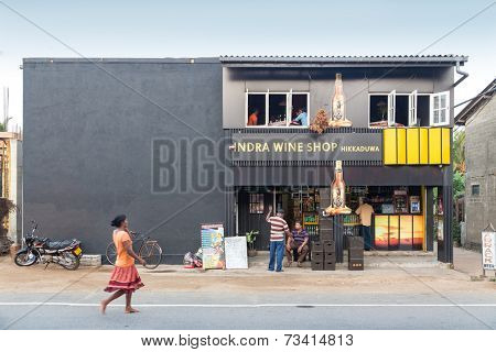 HIKKADUWA, SRI LANKA - FEBRUARY 24, 2014: Local people in front of the Indra Wine Shop. There is no wine production in Sri Lanka, mostly are available Indian, Australian and South African brands.