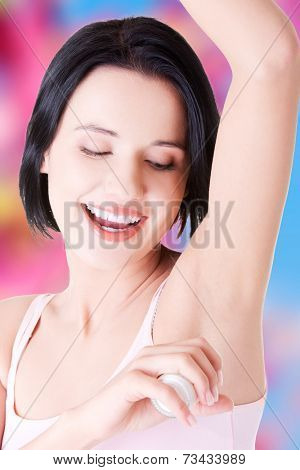 Beautiful young woman using antiperspirant