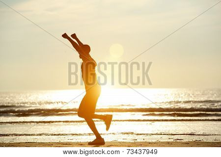 One Man Running On Beach With Arms Raised