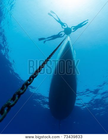 Three free divers relaxing on the surface bouy before diving