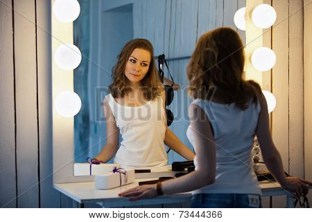 Beautiful Young Woman Looking At Her Reflection In A Dressing Room Mirror
