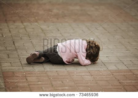 crying girl lying on asphalt