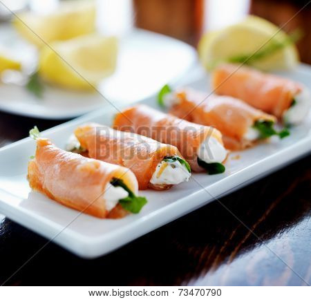 smoked salmon and arugul warp with cream cheese on platter