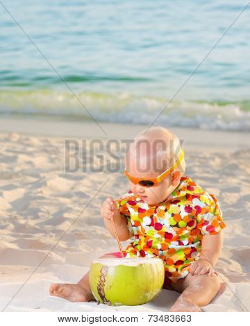 Funny baby with coconut on the beach