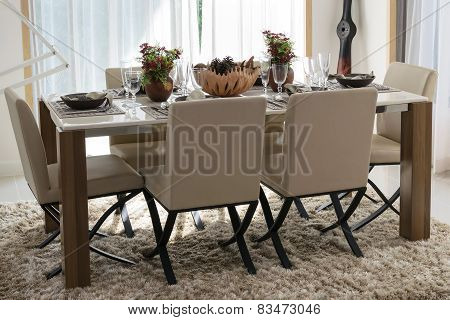 Dining Table And Comfortable Chairs In Modern Home With Elegant Table Setting