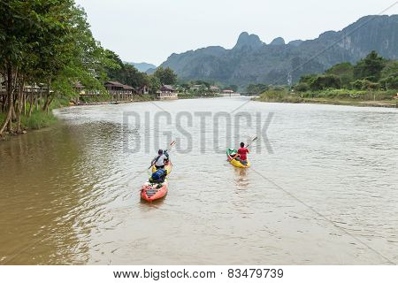 Vang Vieng, Lao P.d.r. - October 24 : Unidentified Tourists Are Rowing Kayak Boats In Song River On