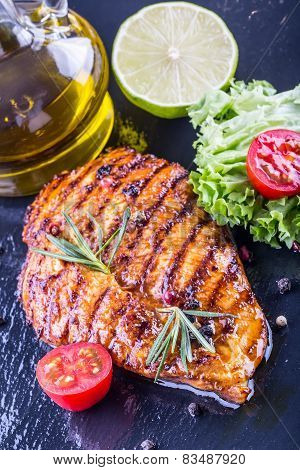 Steak chicken breast olive oil cherry tomatoes pepper and rosemary herbs.