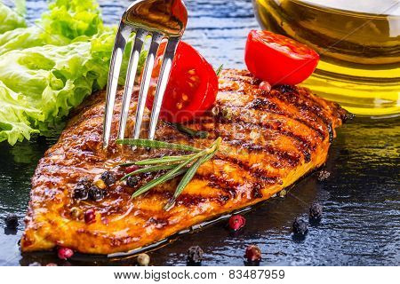 Steak chicken breast olive oil cherry tomatoes pepper and rosemary herbs.