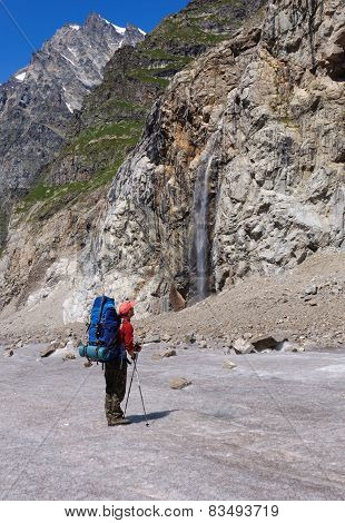 Tourist with a large backpack looks at highest waterfall