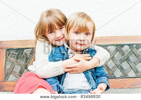 Portrait of adorable children sitting on a bech