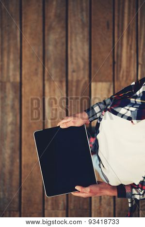 Top view shot of girl holds the tablet with a touch screen on a black background empty wooden floor