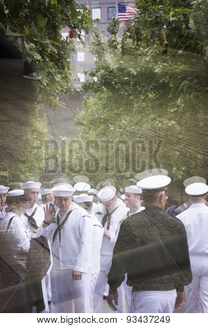 NEW YORK - MAY 22 2015: Reflections of US Navy sailors in the glass of the the National September 11 Museum as they gather for the military re-enlistment and promotion ceremony during Fleet Week 2015.