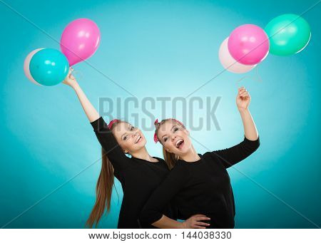 Memory of childhood and forgotten dreams. Two cute lovely retro styled women behave like little girls. Adults trying to fly away by balloons to dream come true.