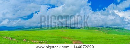 The fluffy clouds lies on the gentle highlands of Gegharkunik Province surrounded by juicy wet meadows Armenia.