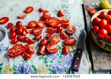 Tomato on wooden table. Freshly Picked red Tomatoes. Variation of tomatoes on wooden surface. Vegetables in the section. Harvesting. Healthy food from the garden.