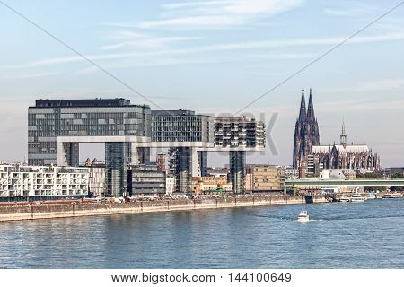 COLOGNE GERMANY - AUG 7 2016: Crane Houses at the Rhine river in Cologne. Cologne cathedral in the background. North Rhine-Westphalia Germany