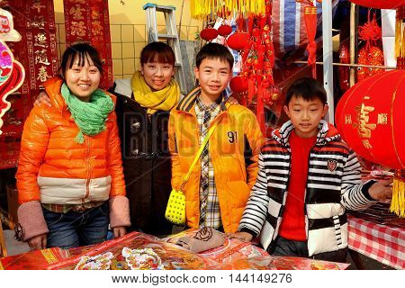 Pengzhou China - January 21 2014: Family members selling Year of the Horse decorations and toys for the Chinese New Year holiday at the Long Xing outdoor marketplace