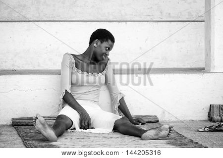 KARA, TOGO - MAR 9, 2013: Unidentified Togolese woman sits near a house. People in Togo suffer of poverty due to the unstable econimic situation