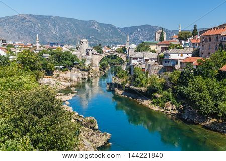 A view of the Mostar skyline during the day towards the Old Bridge (Stari Most). Buildings and the River Neretva can be seen.