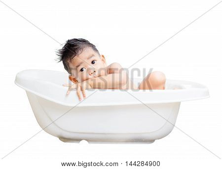 happy baby boy is bathed in white bath