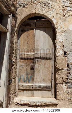Old door in the stone walls of the village houses. Excellent background