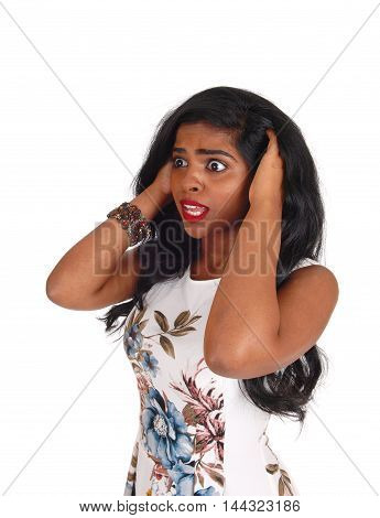 A beautiful young Indian woman with both hands on her head looking very scared isolated for white background.