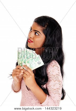 A beautiful young Indian woman holding sine Canadian money looking up and dreaming isolated for white background.