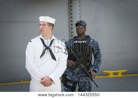 NEW YORK MAY 26 2016: US Navy security personnel stand ready at the USS Bataan (LDH 5) an amphibious assault ship moored at Pier 88 for Fleet Week NY 2016.