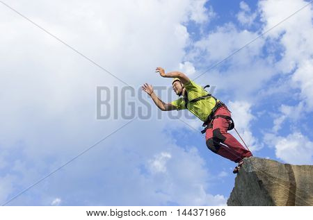 The first jump off the cliff with a safety rope.
