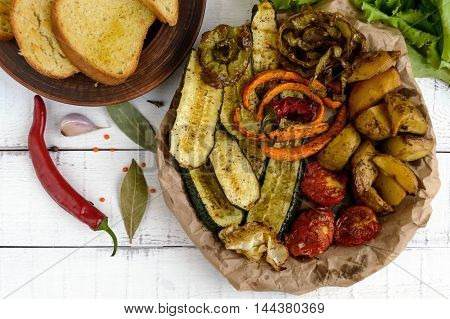 A lot vegetables grilled on a dish (potatoes tomatoes carrots onions zucchini)