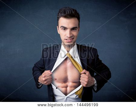 Businessman tearing off his shirt and showing mucular body concept on background