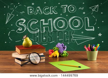 Back to school concepty with writing on blackboard and desk, apple, books, items