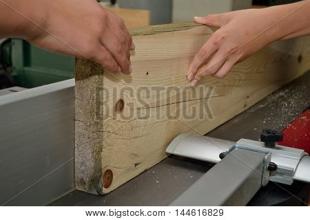 Wooden board is treated by a carpenter on planer