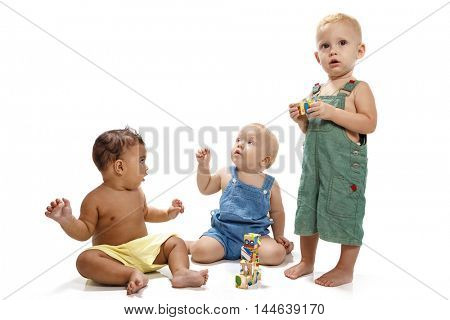 Little boys constructing a toy house with wooden colored bricks