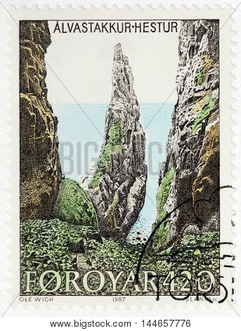 LUGA RUSSIA - JUNE 25 2016: A stamp printed by FAROE ISLANDS shows view of Alvastakkur - a point in Faroe Islands and is nearby to Nakkur Eggjastakkur and Hestur circa 1987.
