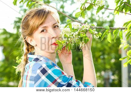 Portrait of a girl with a bird-cherry tree in the spring