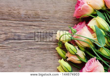 French roses on a wooden background top view. Background of flowers and wood