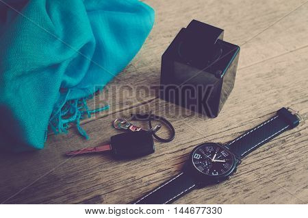 Men's Accessories. Men's fashion. Watches, scarf, perfume and key on wooden background (vintage)