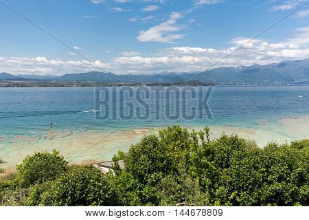 Landscape of the coast of Sirmione peninsula which divides the lower part of Lake Garda. It is a famous vacation place for a long time in northern Italy.