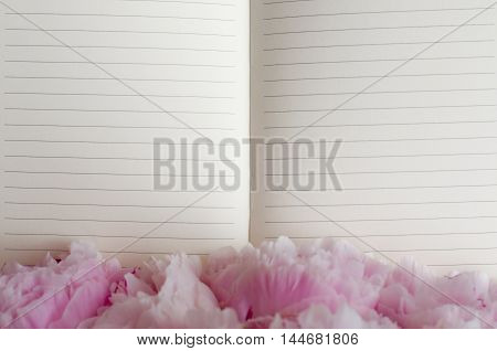 Open notebook for notes, decorated with rose petals