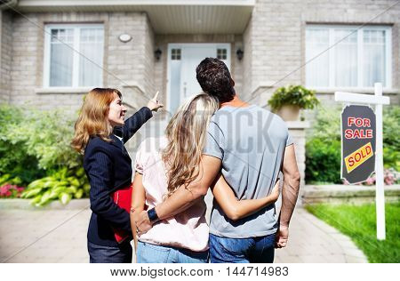 Real Estate agent woman with clients near new house.